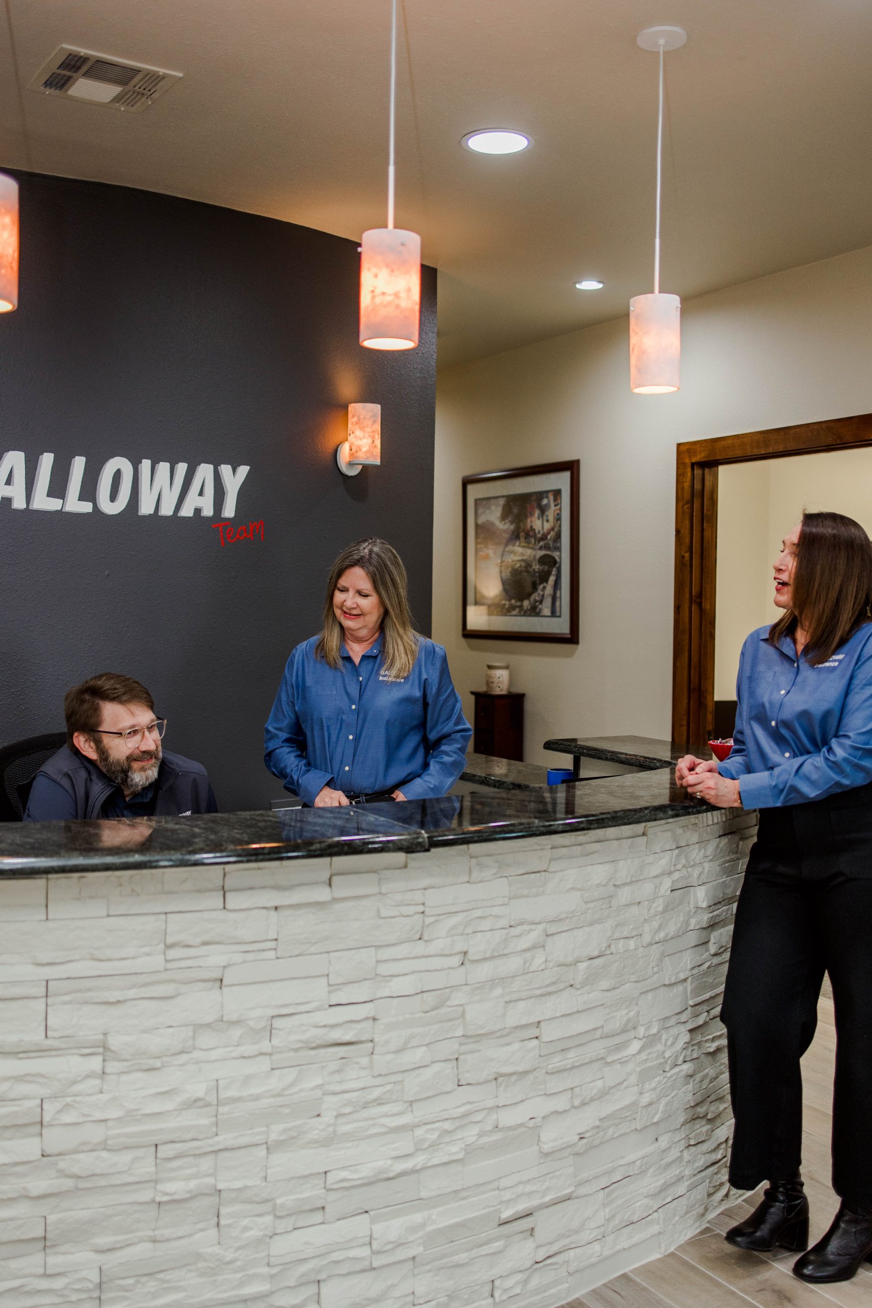 Galloway Insurance team Robin Dahl, Debra Dickens, and Joshua Hughes at the front desk, dedicated to excellent customer service in Texas.