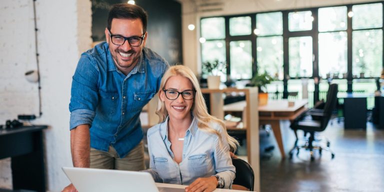 Smiling business owners working together on a laptop - Business Owners Policy Insurance - Galloway Insurance - Marble Falls, Horseshoe Bay, Burnet, TX