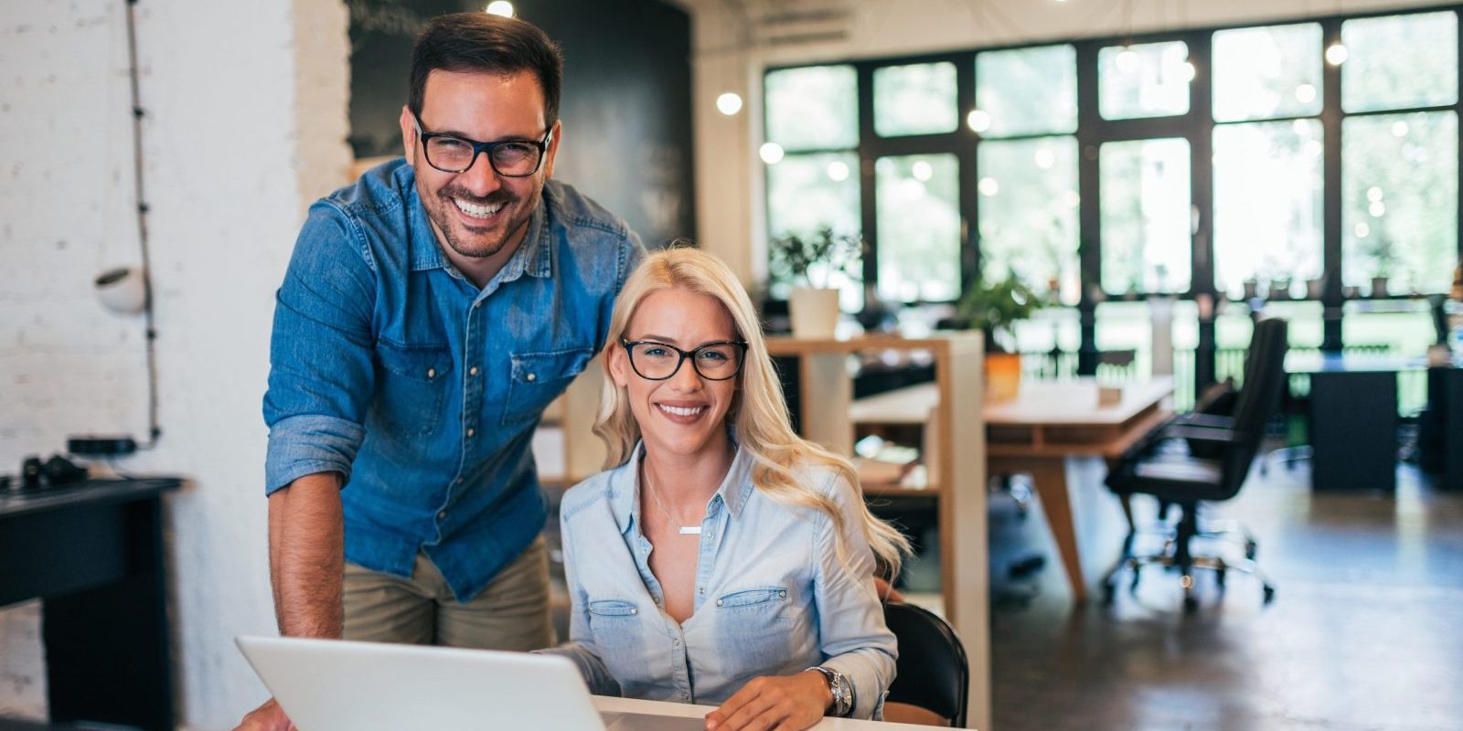 Smiling business owners working together on a laptop - Business Owners Policy Insurance - Galloway Insurance - Marble Falls, Horseshoe Bay, Burnet, TX