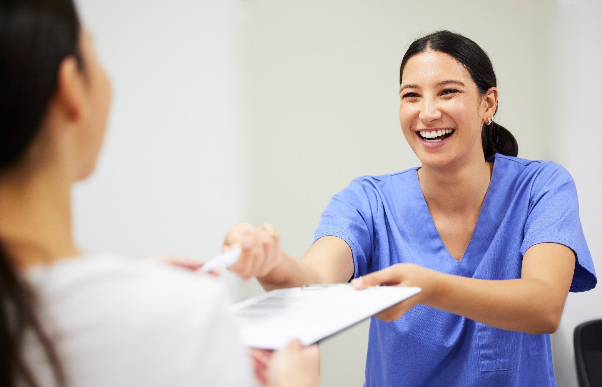 Medical office staff handing over health insurance policy paperwork to patient in Texas